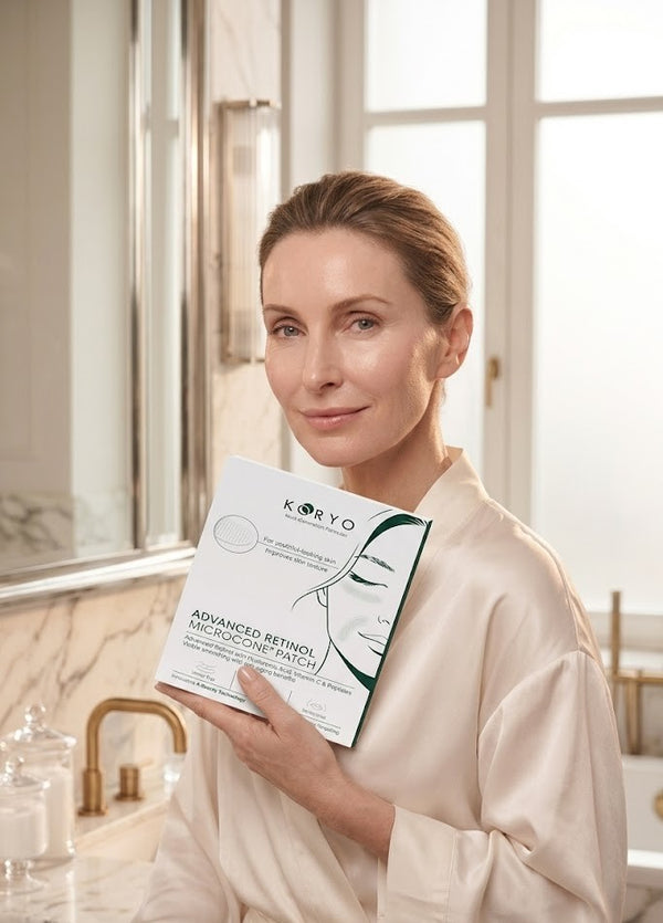 Woman in a robe holding the KORYO Advanced Retinol Microcone Patch box