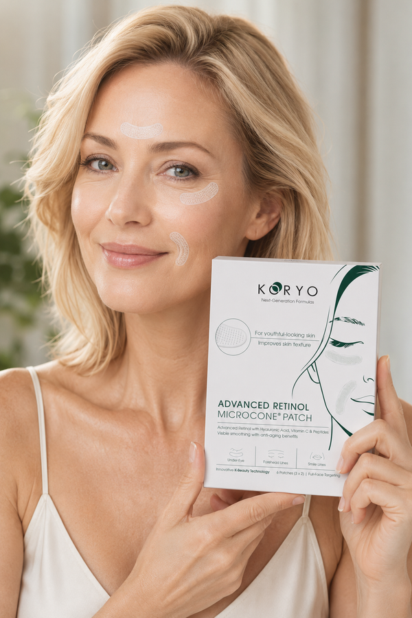 Woman wearing KORYO patches under her eyes, holding the Advanced Retinol Microcone Patch box