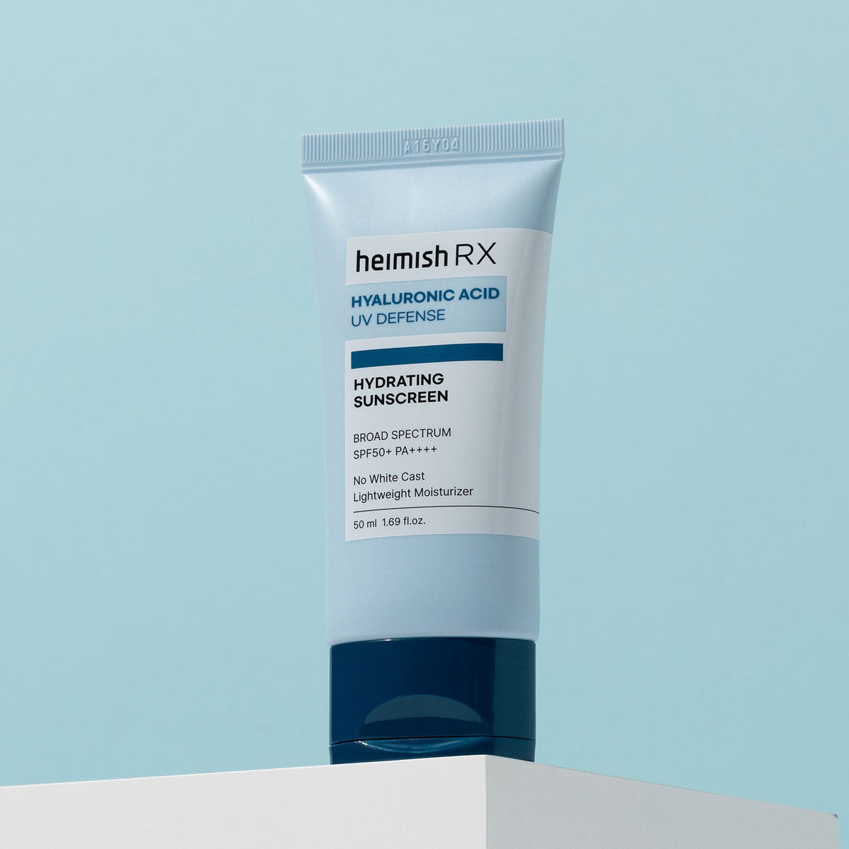Heimish RX Hyaluronic Acid Hydrating Sunscreen 50ml tube standing on a white plinth against pale blue