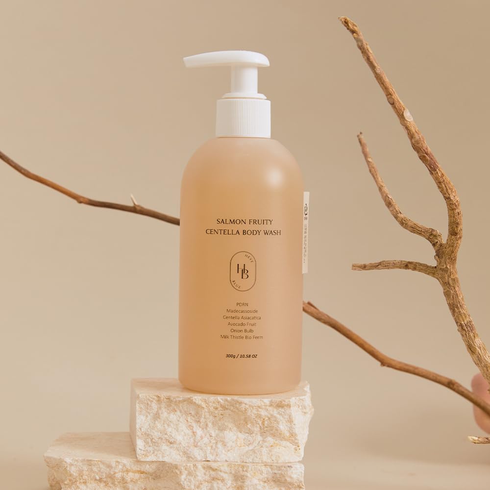 Heveblue Salmon Fruity Centella Body Wash bottle standing on a stone block with a dry branch