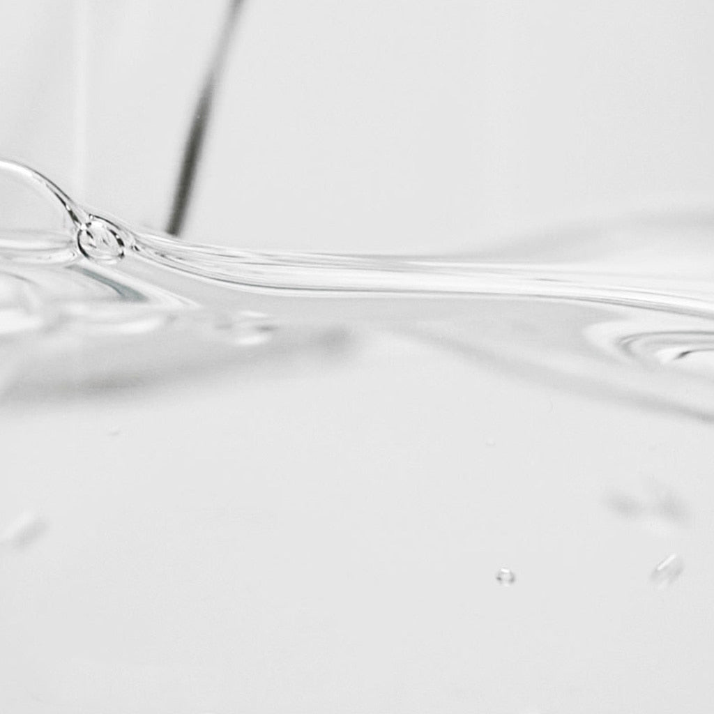 Isntree Hyaluronic Acid Toner clear watery texture streaming across a white surface
