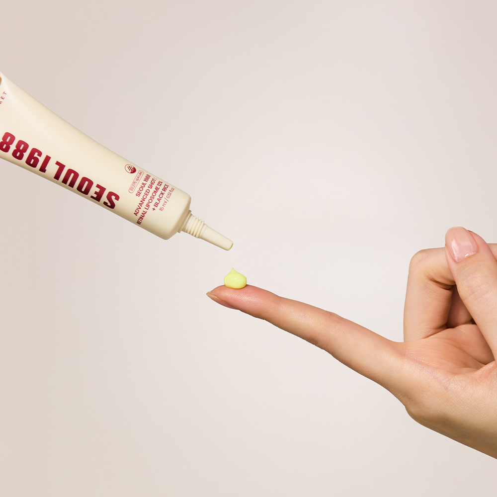 K-Secret Seoul 1988 Advanced Shot Retinal Liposome 12% + Black Rice dispensing a small yellow drop onto a fingertip