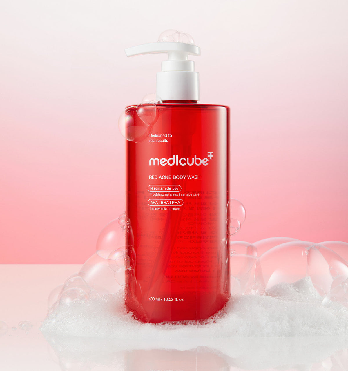 Medicube Red Acne Body Wash 3.0 bottle standing in rich white foam on pink
