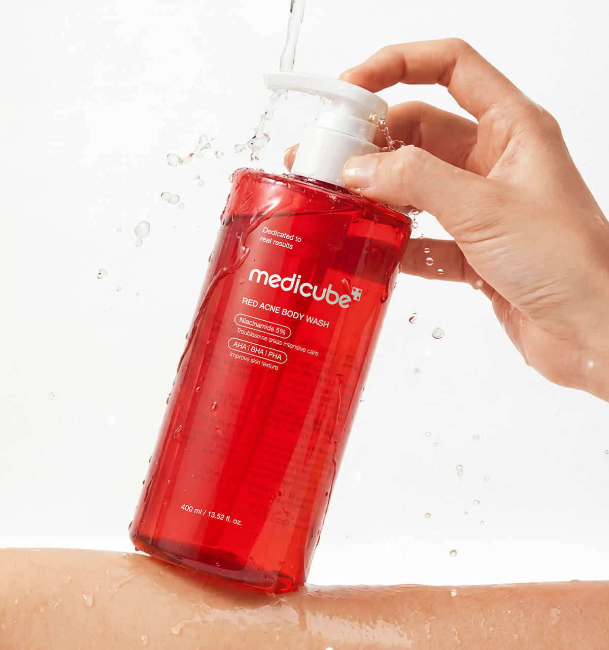 Medicube Red Acne Body Wash 3.0 being pumped under running water