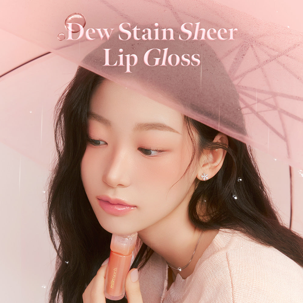 Milk Touch Dew Stain Sheer Lip Gloss held by a model under a sheer pink umbrella