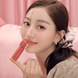 Milk Touch Jelly Fit Tinted Glow Tint tube held by a model with glossy coral lips