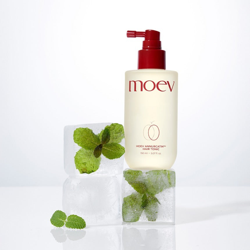MOEV Annurcatin Hair Tonic 150ml cream bottle with red spray nozzle on ice cubes with fresh mint