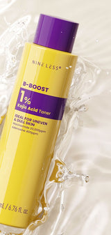 Nine Less B-Boost 1% Kojic Acid Toner 200ml renewed yellow bottle with purple cap in a clear water splash