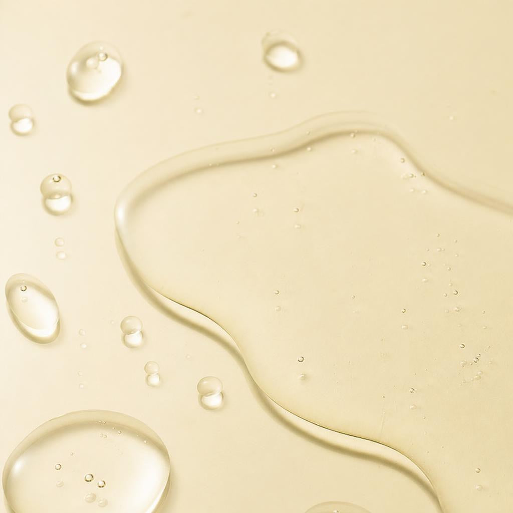 Nine Less B-Boost 1% Kojic Acid Toner clear watery texture with droplets on a pale yellow surface