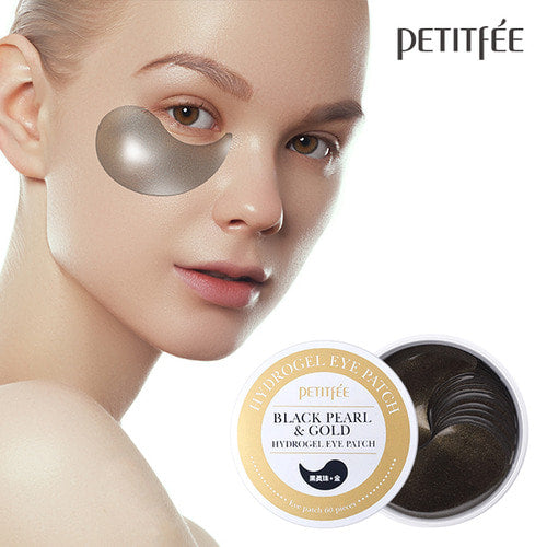 Petitfee Black Pearl & Gold Hydrogel Eye Patch worn under the eye by a model beside the open jar