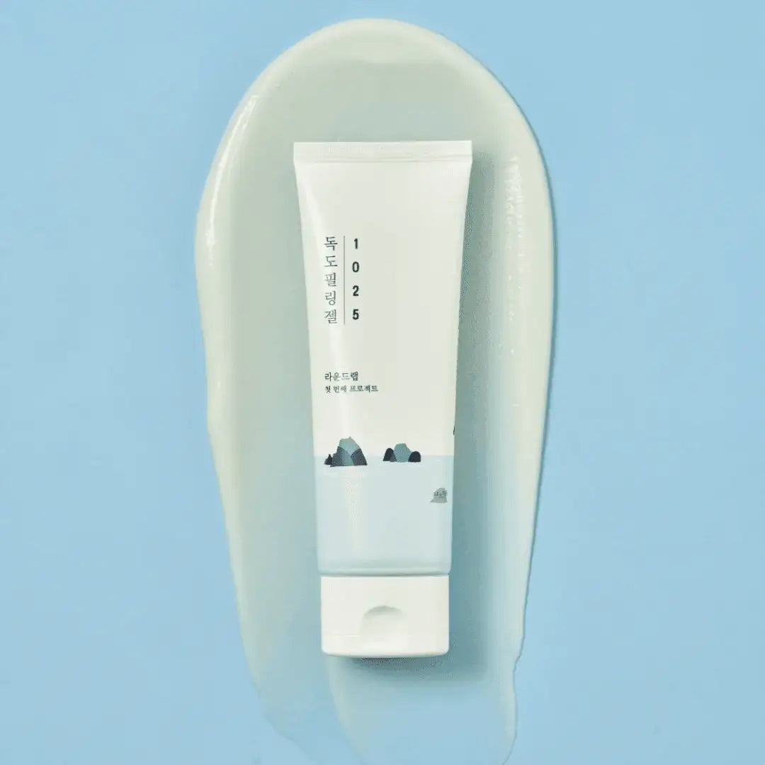 Round Lab 1025 Dokdo Peeling Gel tube lying on a smear of the milky gel on a blue background