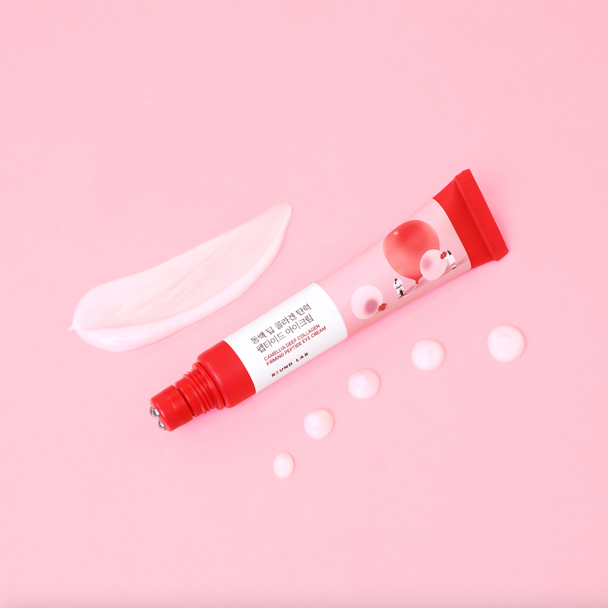 Round Lab Camellia Deep Collagen Eye Cream tube with roller tip beside a swatch and dots of pale pink cream